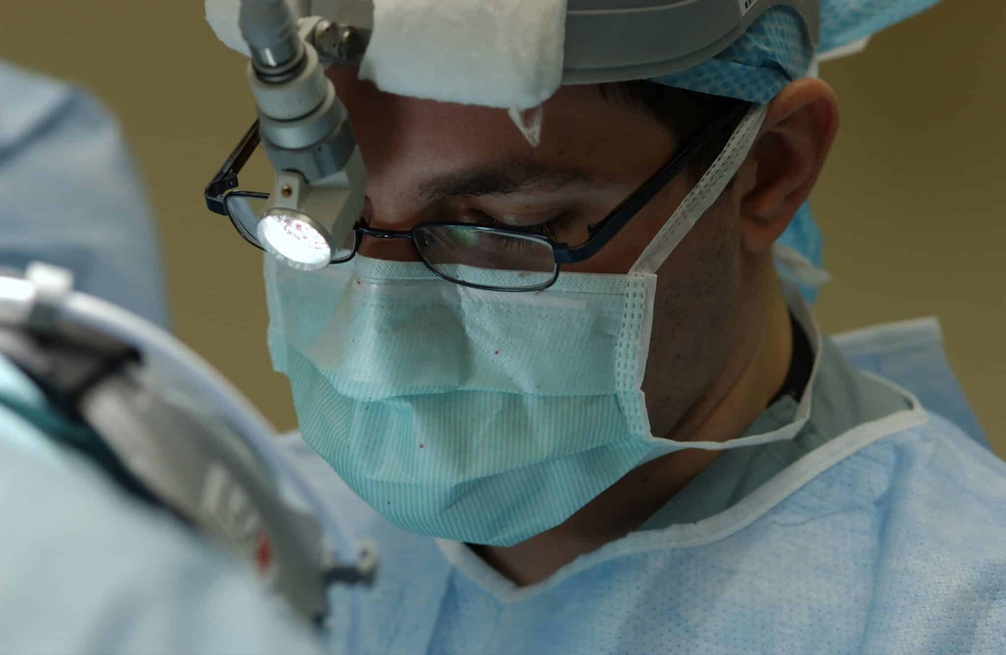 Surgeon wearing a mask during surgery.